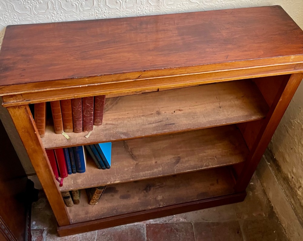 A low Victorian open mahogany bookcase featuring three wide shelves, exposed vertical backboards, a top edge, and a plinth base. View III