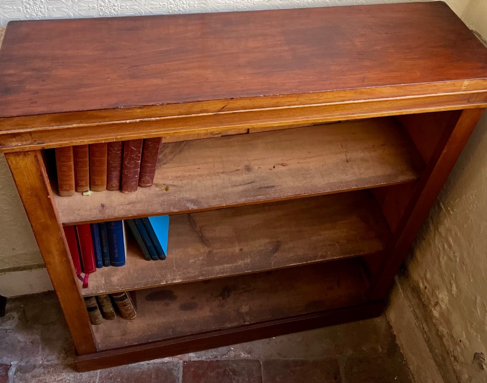 A low Victorian open mahogany bookcase featuring three wide shelves, exposed vertical backboards, a top edge, and a plinth base. View IV