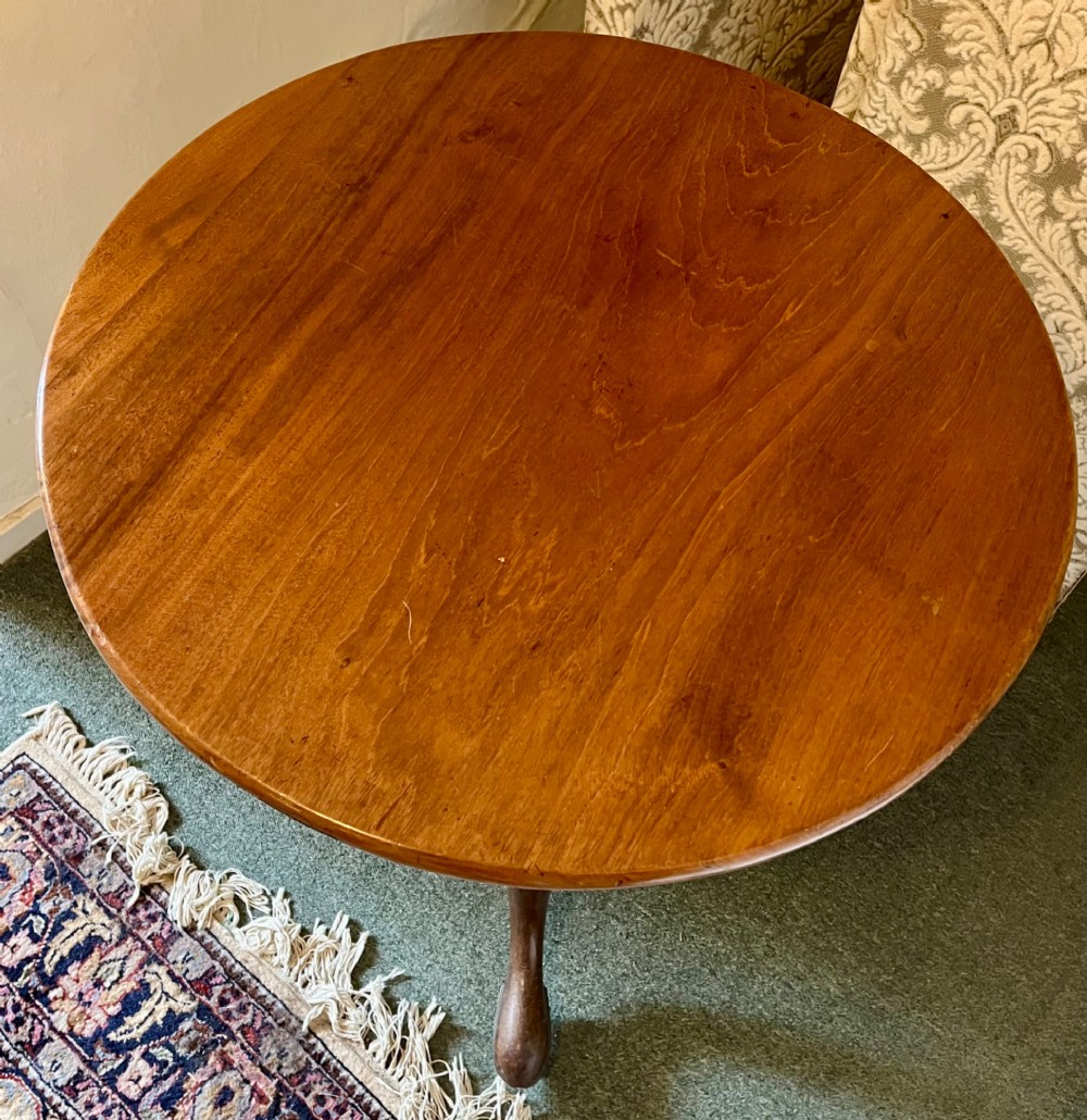 A nineteenth-century mahogany tripod table featuring a circular top resting on a turned and carved central pedestal with three cabriole legs. View II