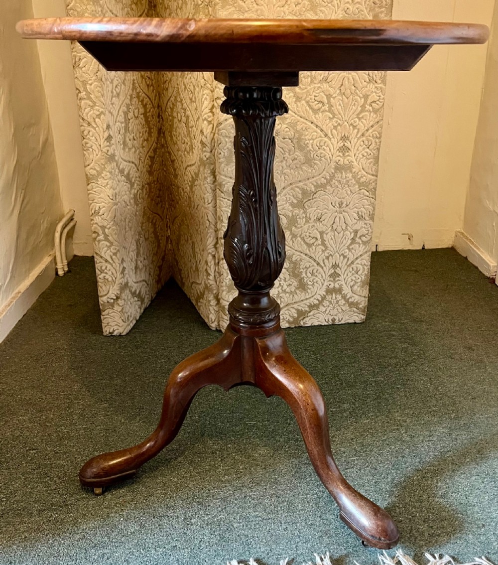 A nineteenth-century mahogany tripod table featuring a circular top resting on a turned and carved central pedestal with three cabriole legs. View IV