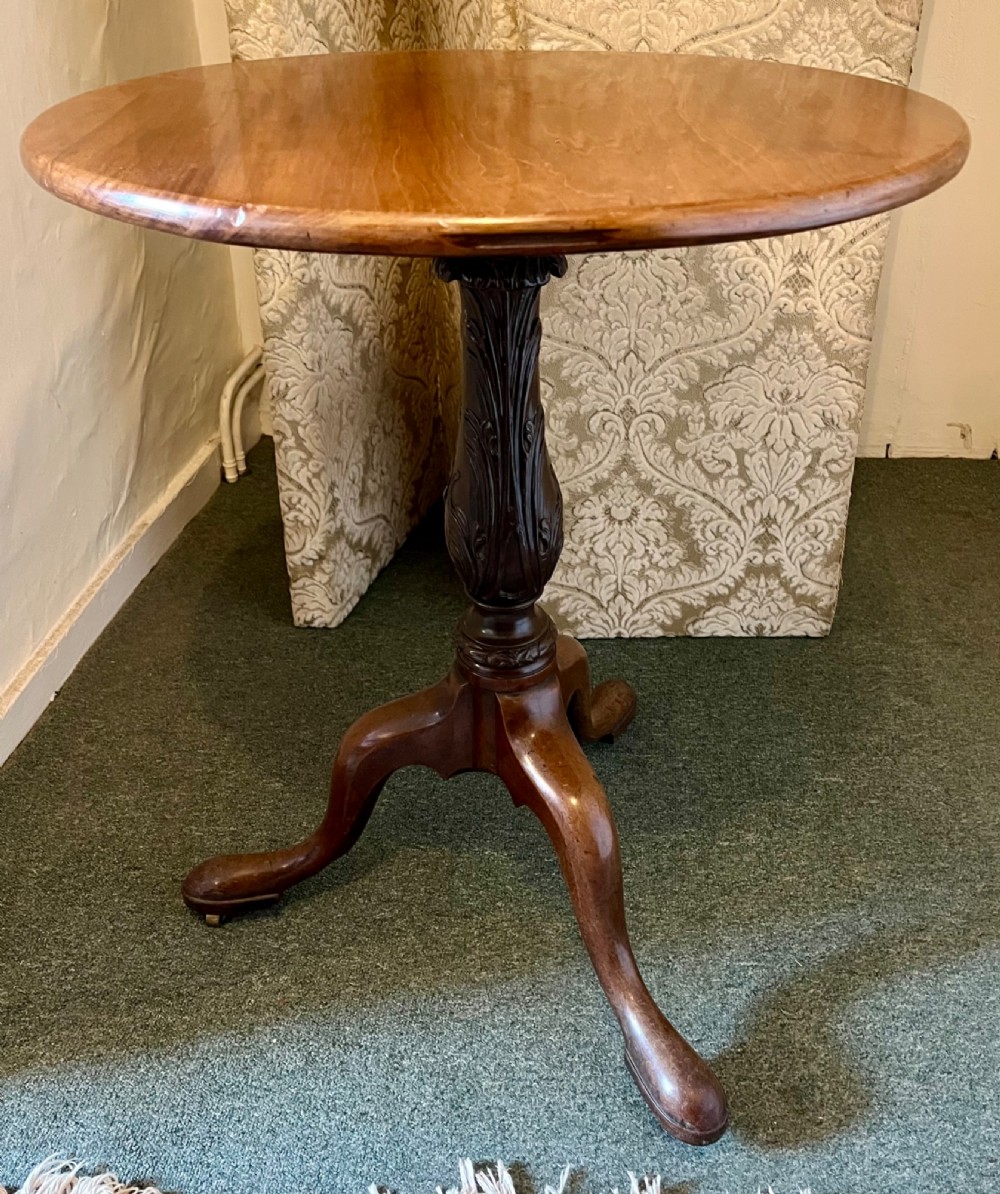 A nineteenth-century mahogany tripod table featuring a circular top resting on a turned and carved central pedestal with three cabriole legs. View VIII