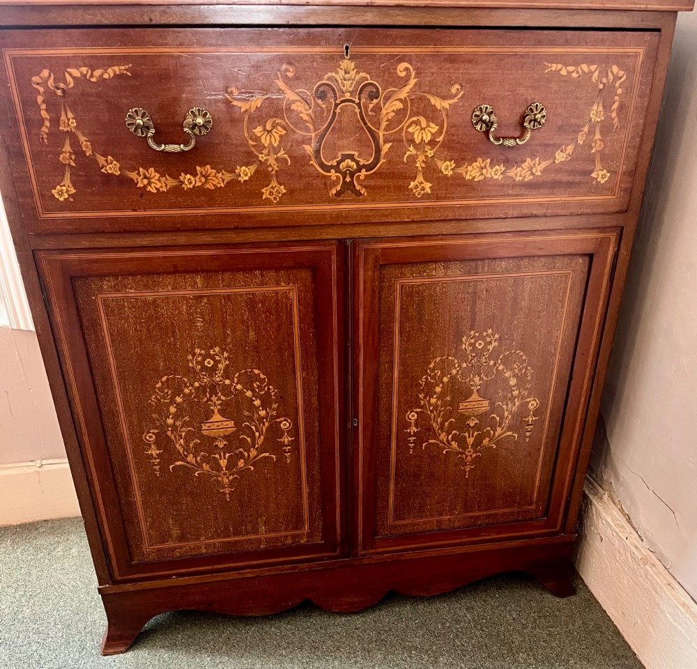 An Edwardian mahogany secretaire bookcase featuring satinwood marquetry inlays, a swan-neck pediment, glazed upper doors, and a pull-out desk drawer above lower cupboards. View V