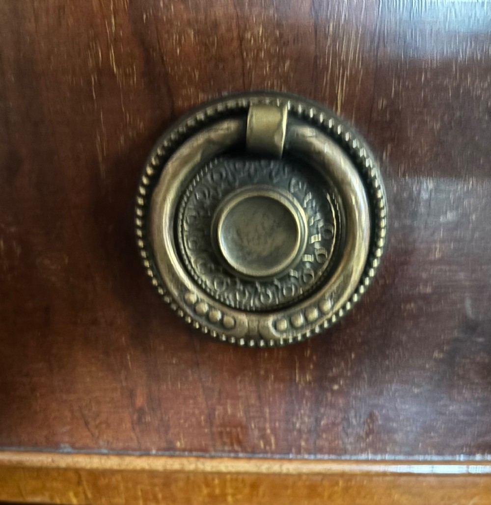 A small Edwardian mahogany bow front chest of drawers featuring four graduated drawers with brass ring drop handles and bracket feet. View VII
