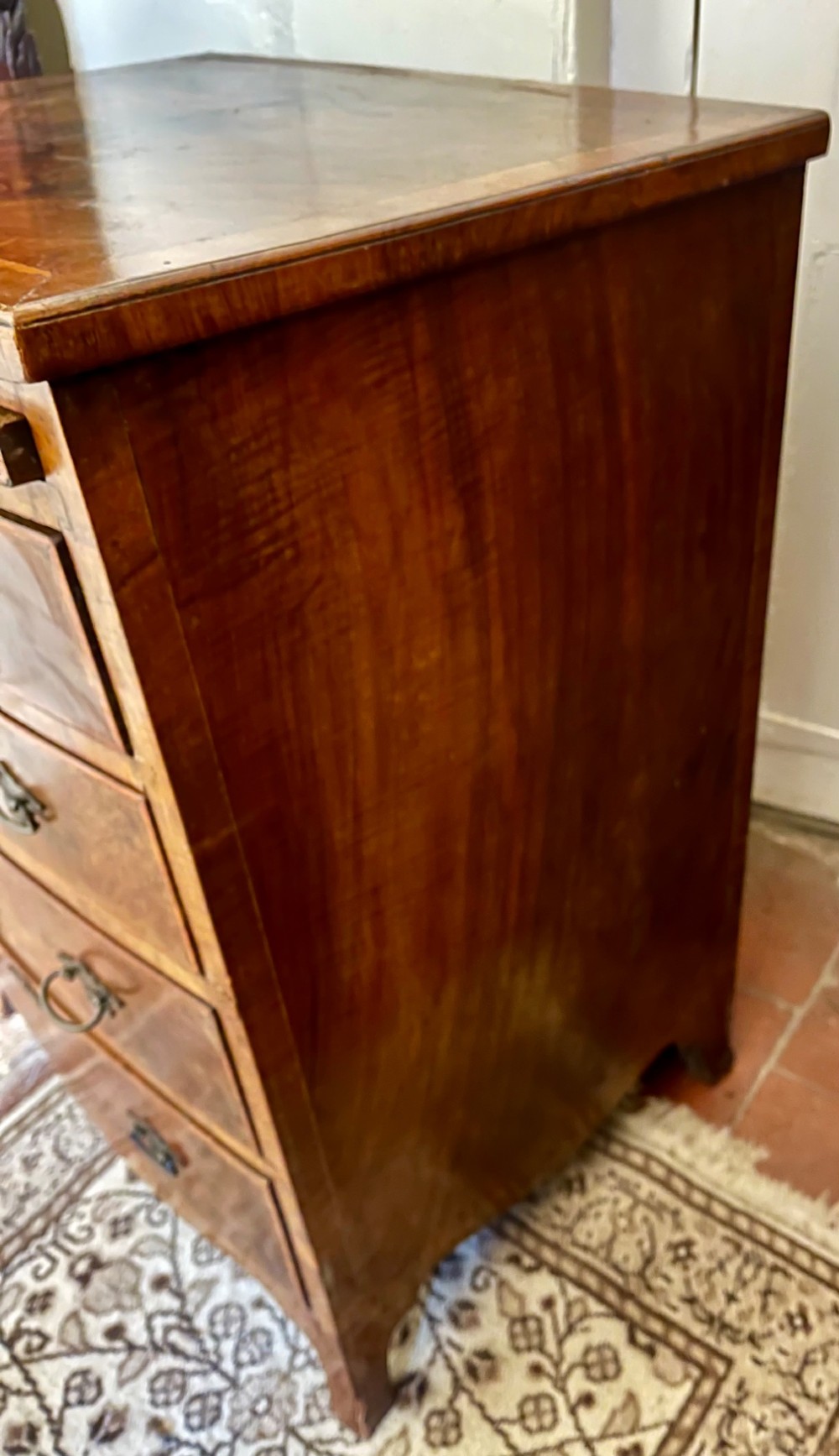 An Edwardian bow-fronted chest of drawers crafted from figured walnut with brass handles and cross-banded detailing. View VIII