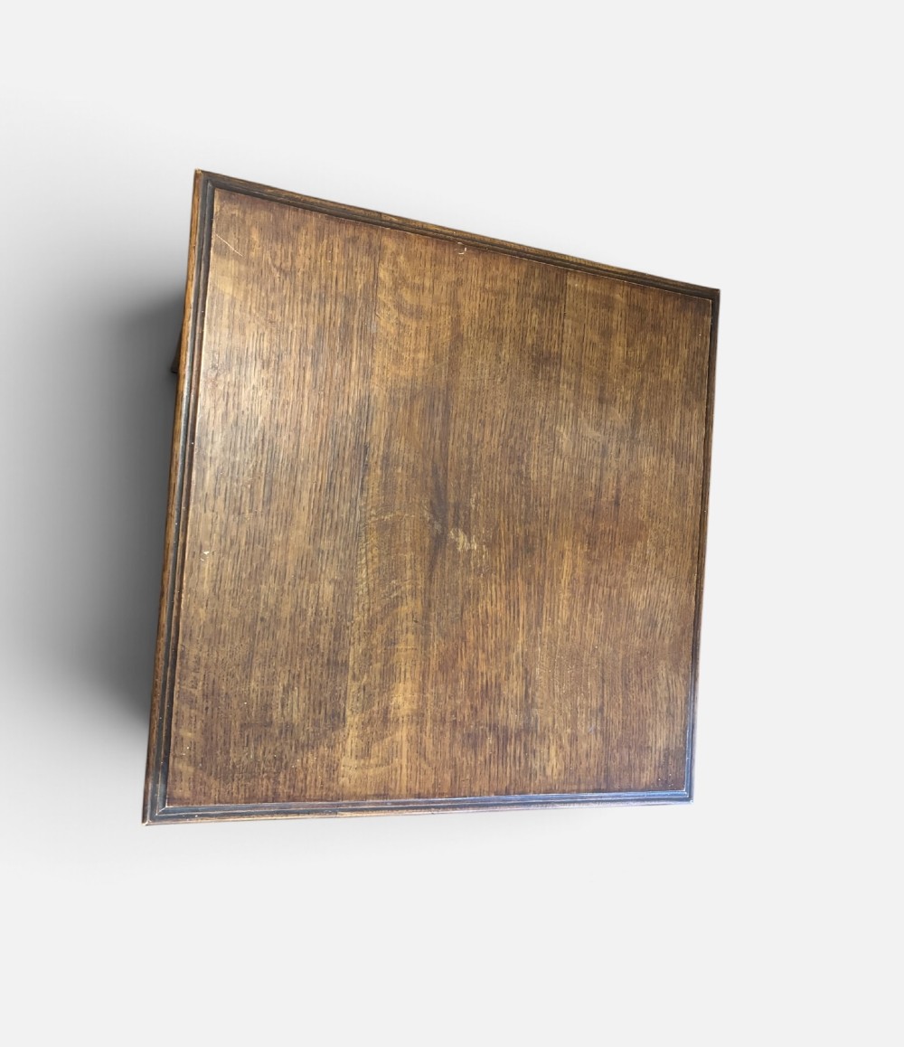 An Edwardian oak revolving bookcase featuring two tiers with vertical slatted sides mounted on a rotating central base. View III