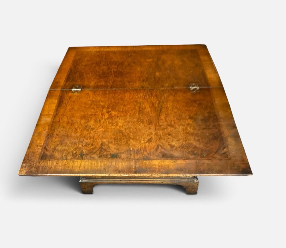 An antique burr walnut bachelors chest featuring a hinged fold-over top, four graduated drawers with brass handles, and bracket feet. View III
