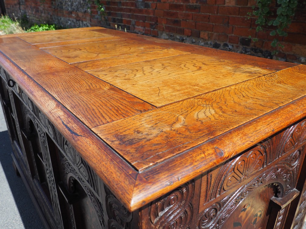 A rectangular carved oak coffer with three arcaded front panels featuring floral inlay and a flat panelled top. View III