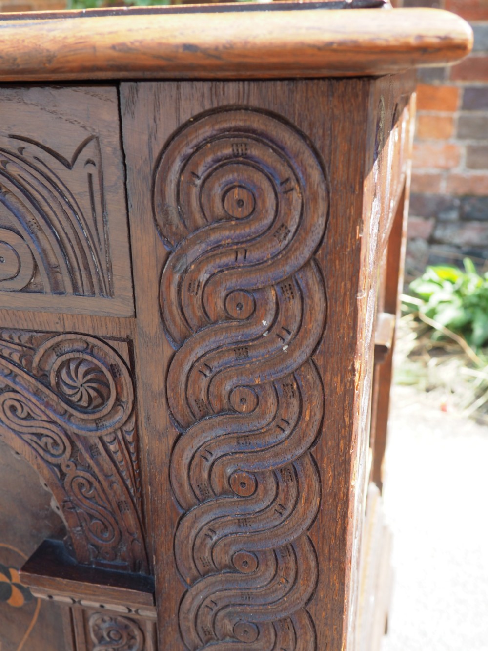 A rectangular carved oak coffer with three arcaded front panels featuring floral inlay and a flat panelled top. View VIII