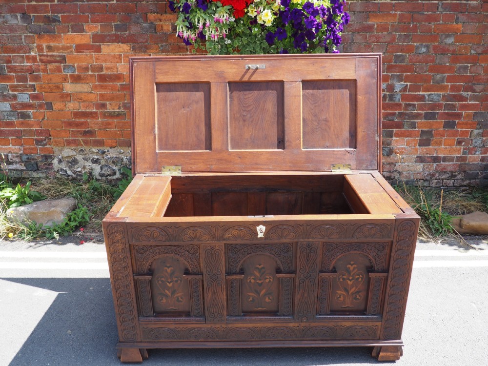 A rectangular carved oak coffer with three arcaded front panels featuring floral inlay and a flat panelled top. View IX