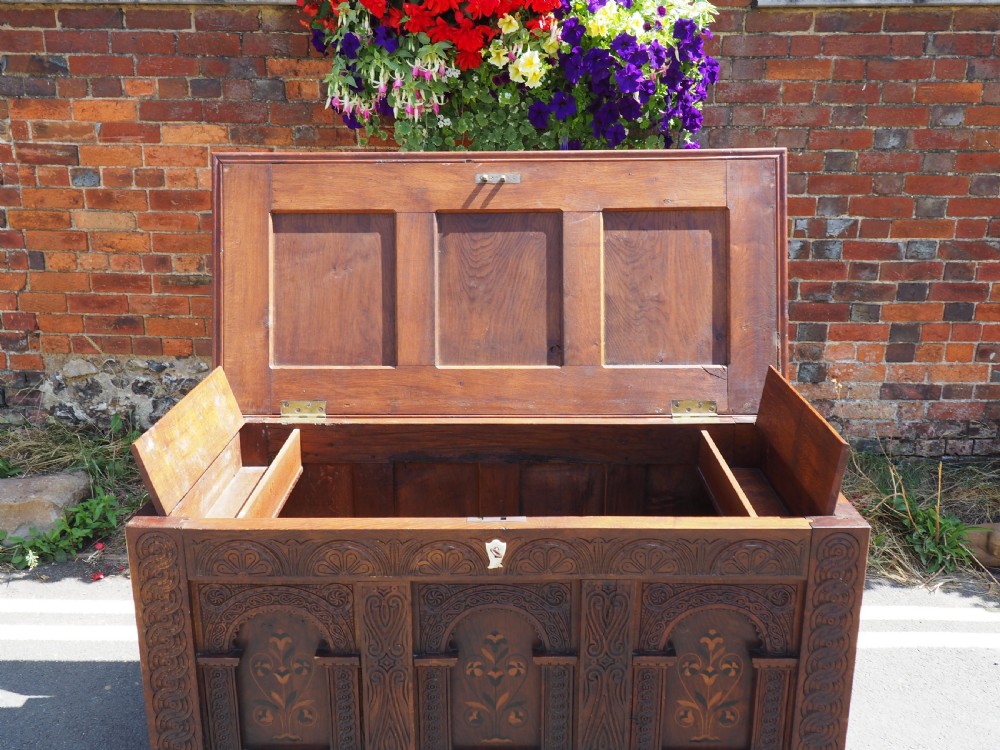A rectangular carved oak coffer with three arcaded front panels featuring floral inlay and a flat panelled top. View X