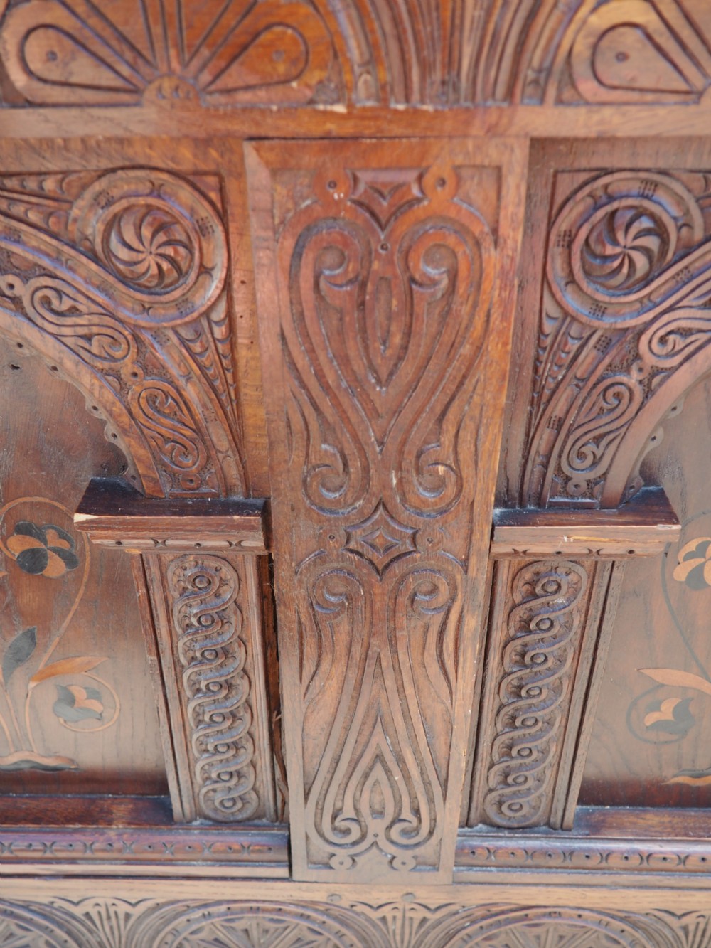 A rectangular carved oak coffer with three arcaded front panels featuring floral inlay and a flat panelled top. View XI