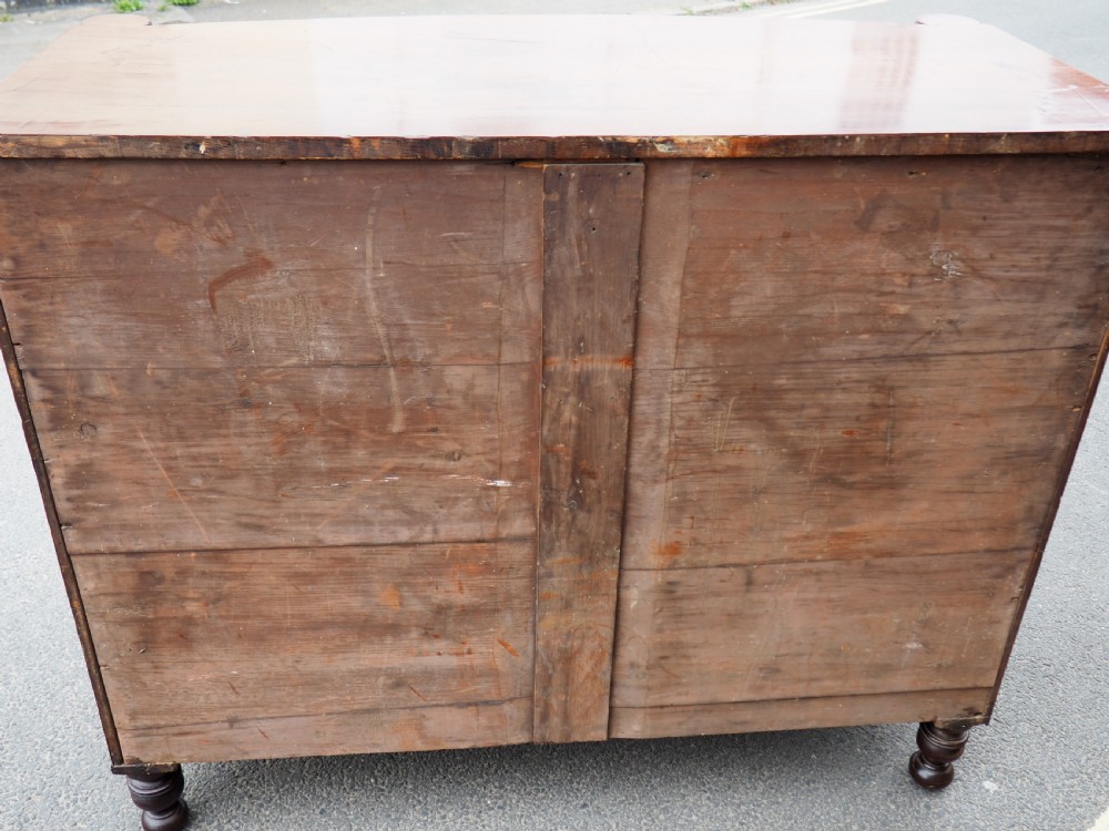 A Regency period mahogany bowfront chest of drawers featuring three full-width drawers, spiral-turned side columns, and circular brass handles. View XIII