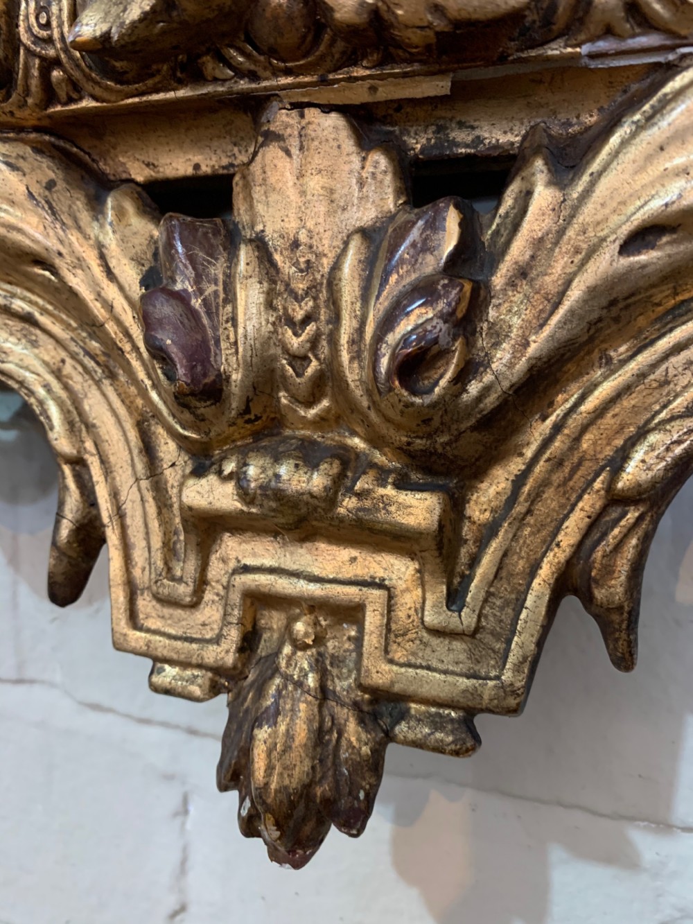 A nineteenth-century rectangular giltwood wall mirror featuring a carved crest with a sculpted mask, winged creatures, and star-etched border panels. View X