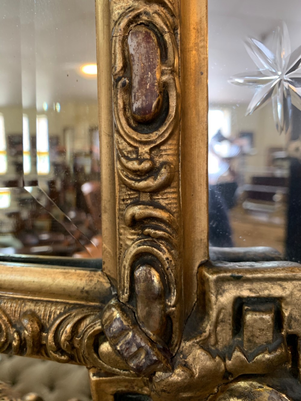 A nineteenth-century rectangular giltwood wall mirror featuring a carved crest with a sculpted mask, winged creatures, and star-etched border panels. View XI