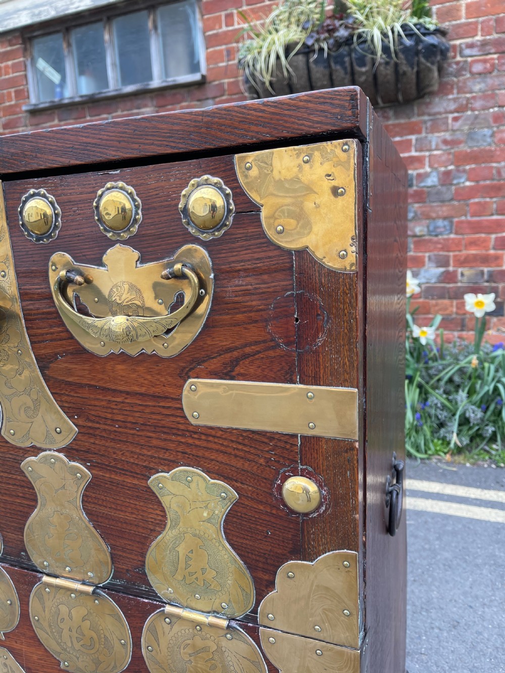 A traditional Korean elm wood Bandaji chest featuring decorative brass mounts, side handles, and a drop-front upper panel. View II