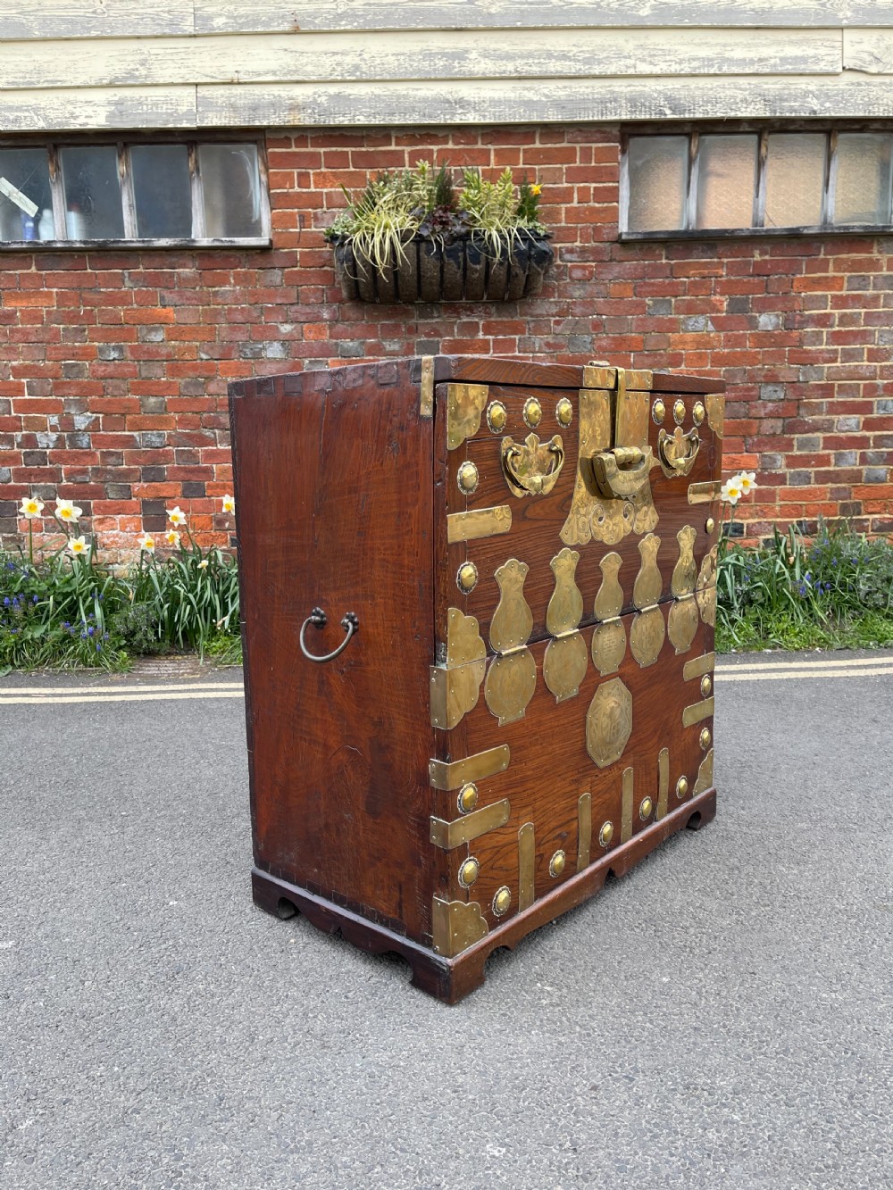 A traditional Korean elm wood Bandaji chest featuring decorative brass mounts, side handles, and a drop-front upper panel. View V