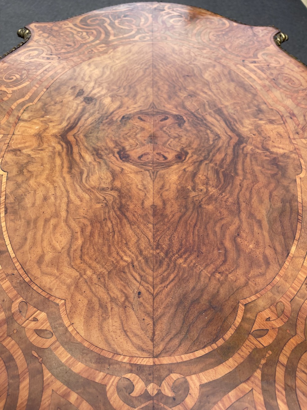 A 19th-century French style walnut centre table featuring a shaped serpentine top with floral marquetry inlay, slender cabriole legs, and ornate gilt bronze mounts. View IV