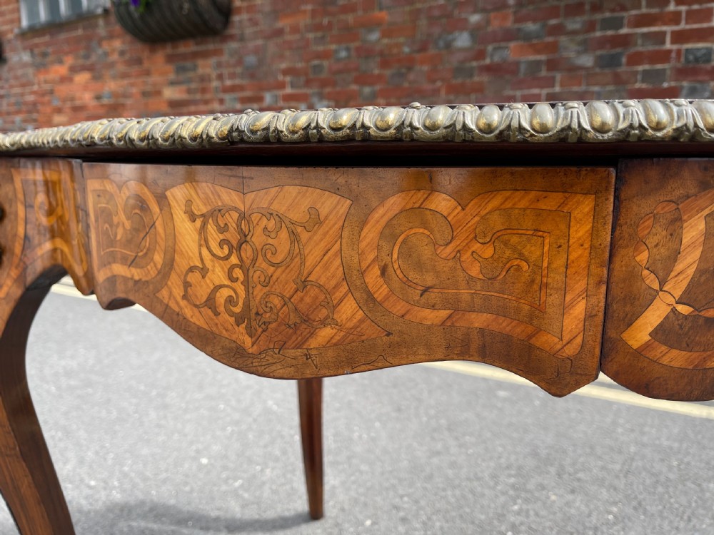 A 19th-century French style walnut centre table featuring a shaped serpentine top with floral marquetry inlay, slender cabriole legs, and ornate gilt bronze mounts. View IX