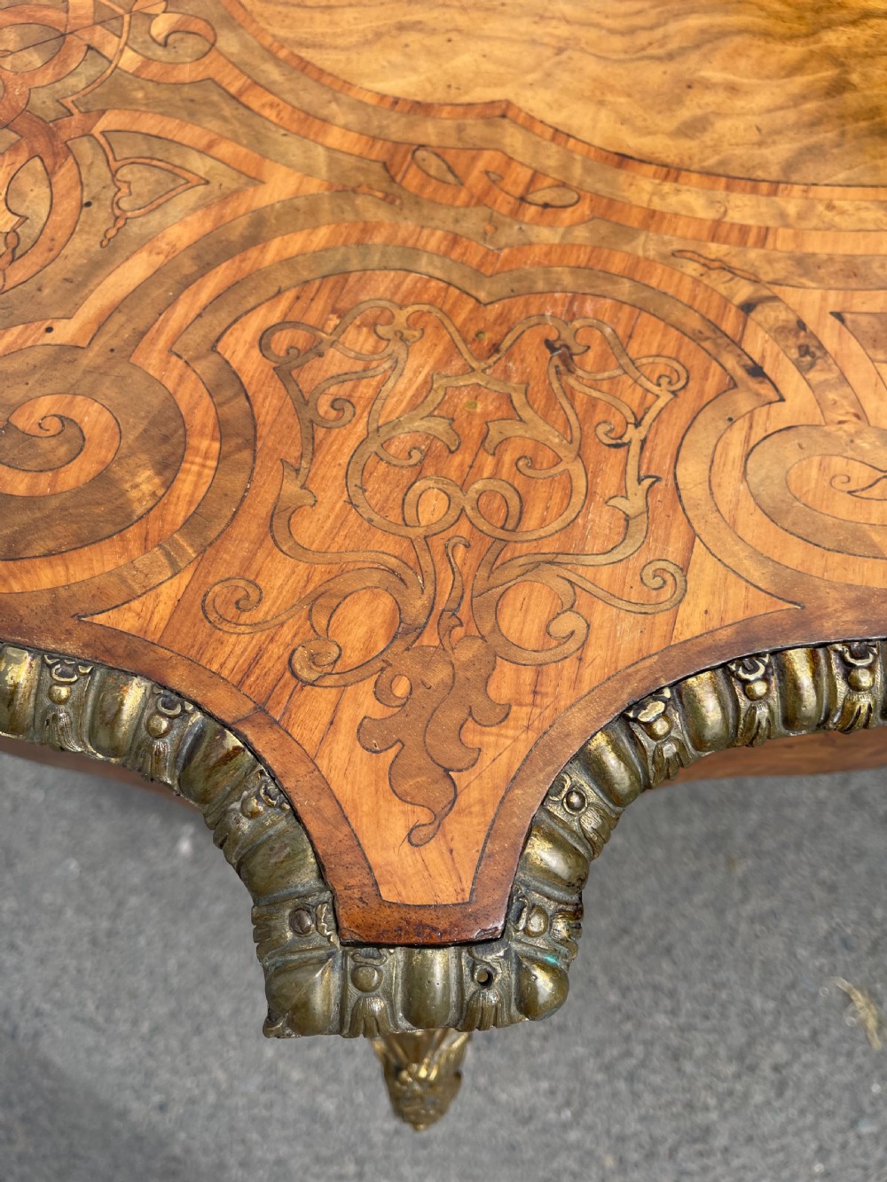 A 19th-century French style walnut centre table featuring a shaped serpentine top with floral marquetry inlay, slender cabriole legs, and ornate gilt bronze mounts. View X