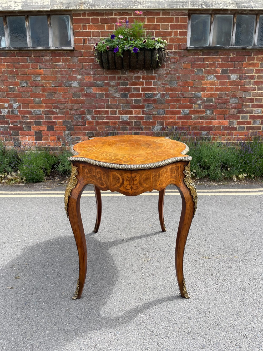 A 19th-century French style walnut centre table featuring a shaped serpentine top with floral marquetry inlay, slender cabriole legs, and ornate gilt bronze mounts. View XI