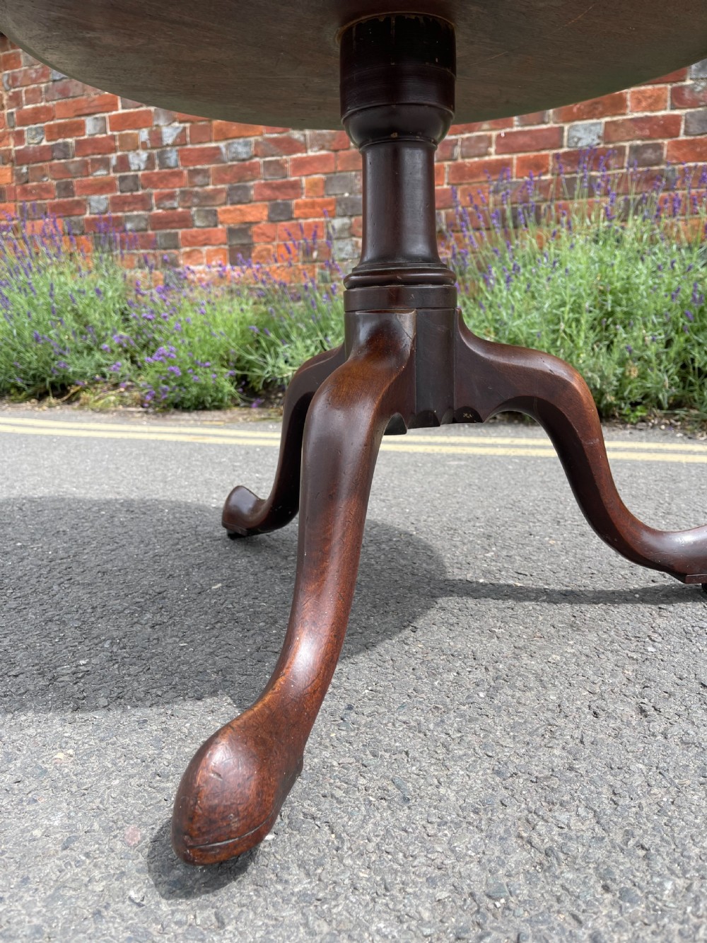 A George III mahogany three-tier dumb waiter featuring graduated circular trays supported by turned stem sections and a tripod base with pad feet. View III
