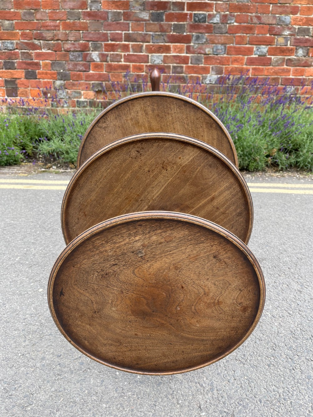 A George III mahogany three-tier dumb waiter featuring graduated circular trays supported by turned stem sections and a tripod base with pad feet. View VI