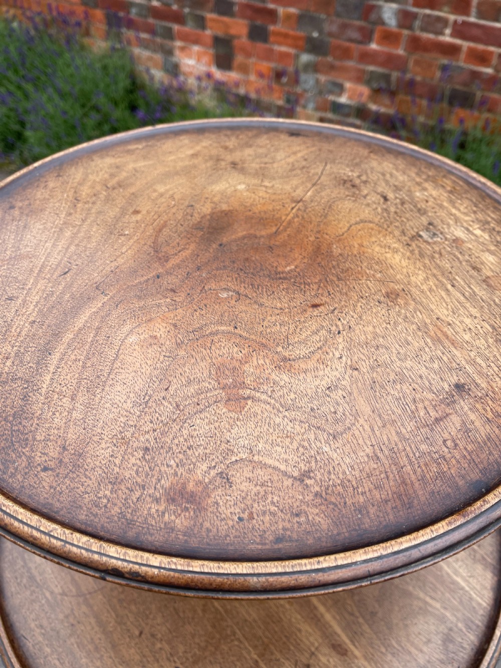 A George III mahogany three-tier dumb waiter featuring graduated circular trays supported by turned stem sections and a tripod base with pad feet. View IX
