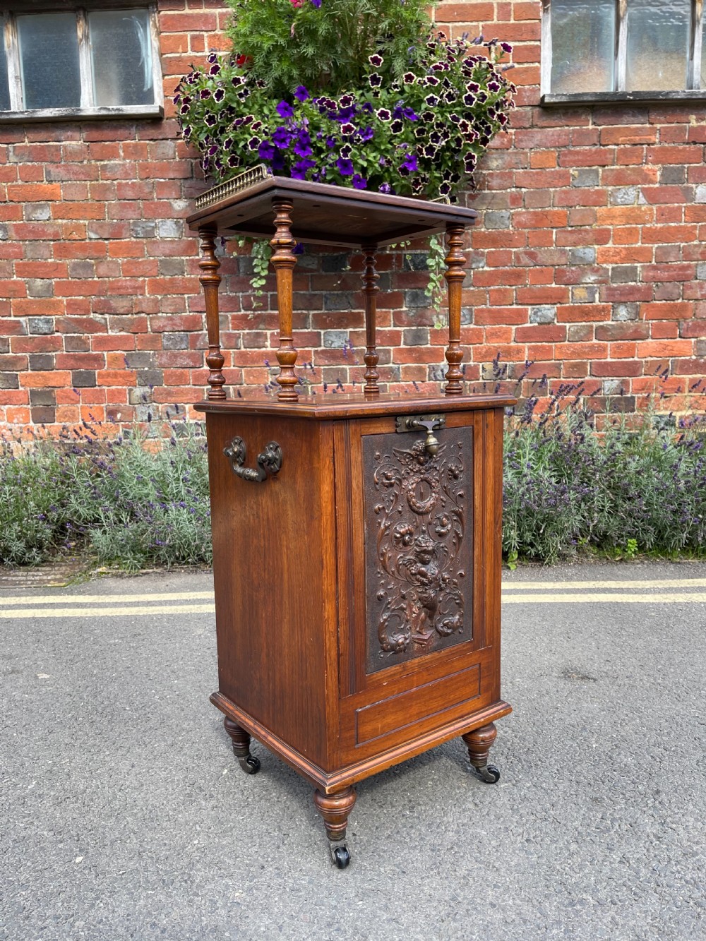 Victorian walnut purdonium featuring an upper shelf on turned spindles with a brass gallery above a carved drop-front compartment.