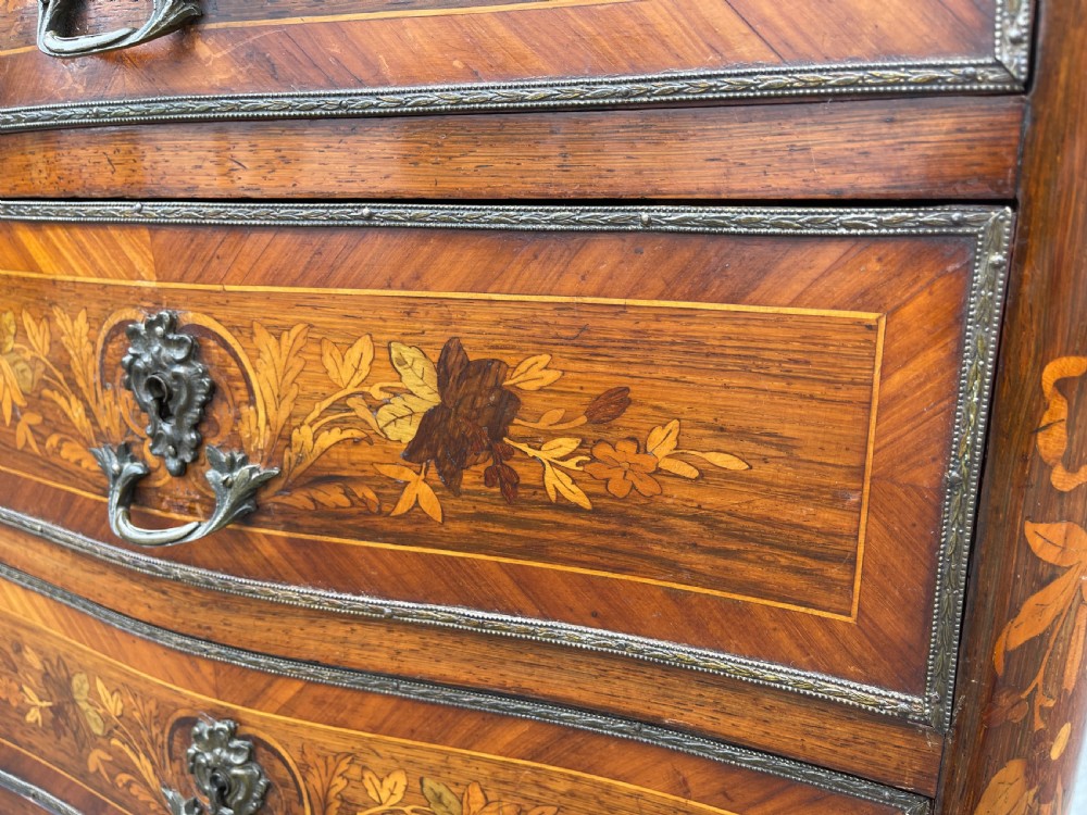 A tall, narrow 19th-century French rosewood semainier chest featuring seven drawers with floral marquetry inlay, bronze handles, and a marble top. View V