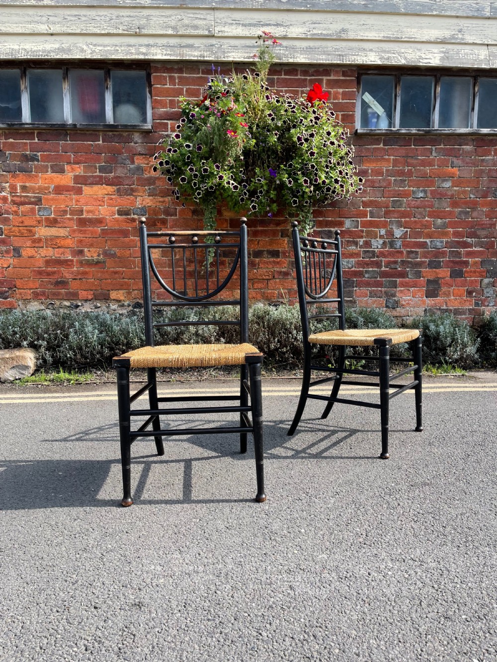 Pair of Heals ebonised Sussex chairs 