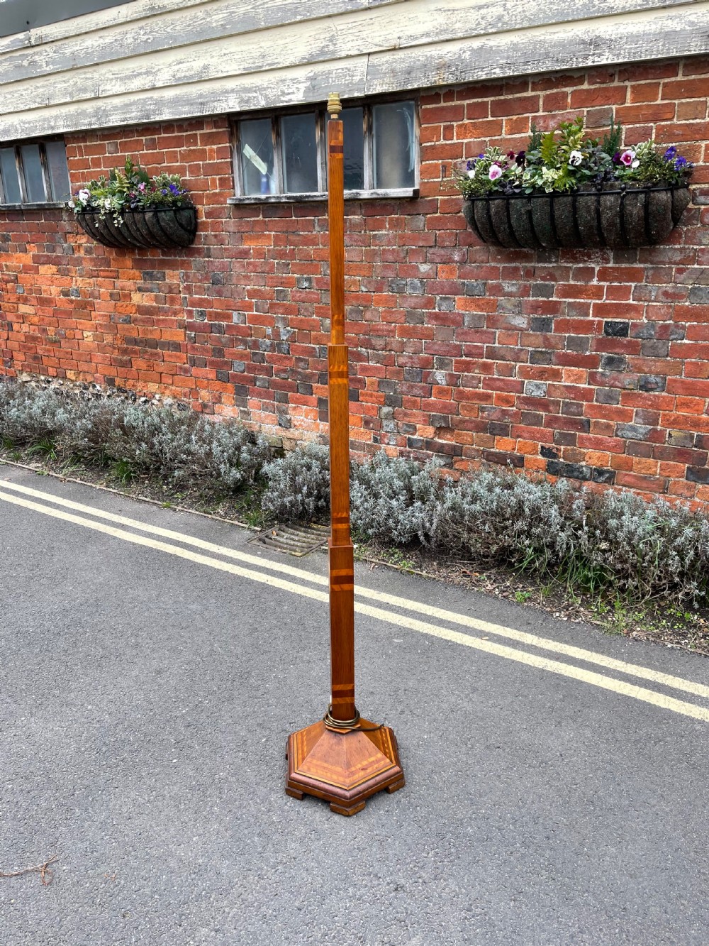 A tall Art Deco wooden standard lamp featuring geometric marquetry banding and a stepped hexagonal base.