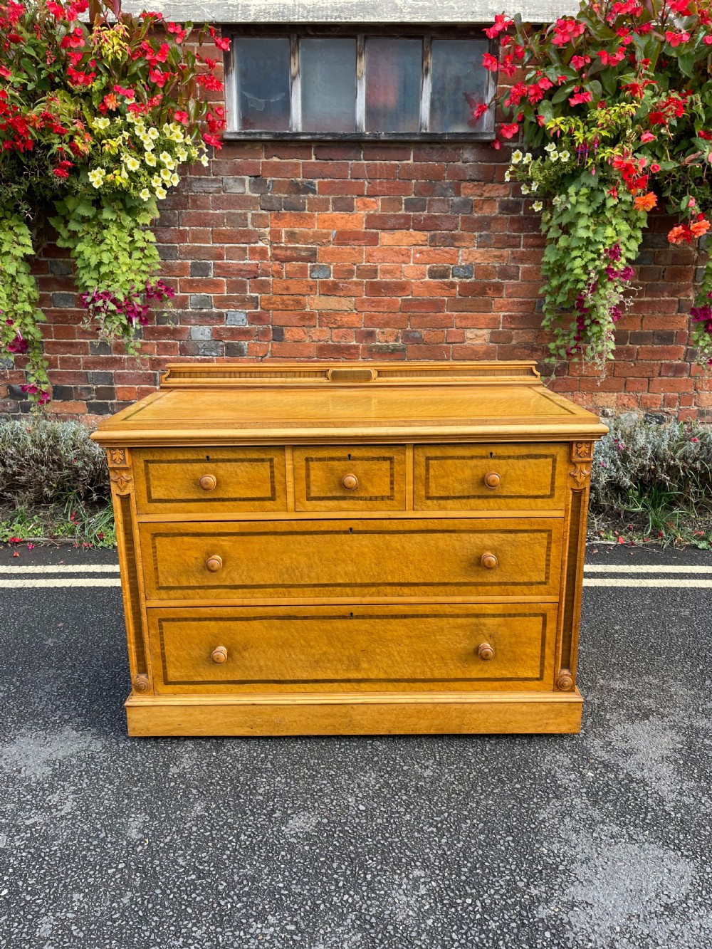 An antique birdseye maple chest of drawers featuring three upper drawers, two long lower drawers, turned handles, and dark wood inlay borders. View X