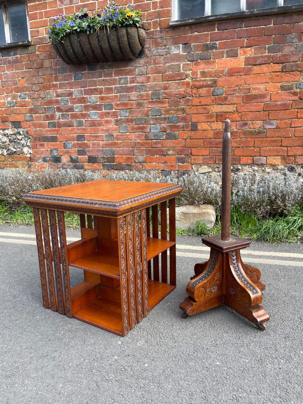 An Anglo-Indian carved wood revolving bookcase featuring vertical foliate slats and a tiered pedestal base. View VI