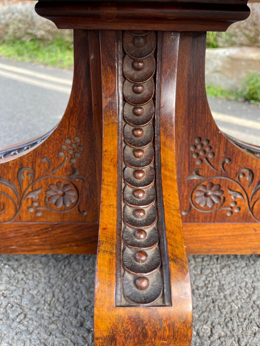 An Anglo-Indian carved wood revolving bookcase featuring vertical foliate slats and a tiered pedestal base. View VII