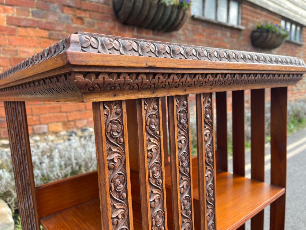 An Anglo-Indian carved wood revolving bookcase featuring vertical foliate slats and a tiered pedestal base. View XI