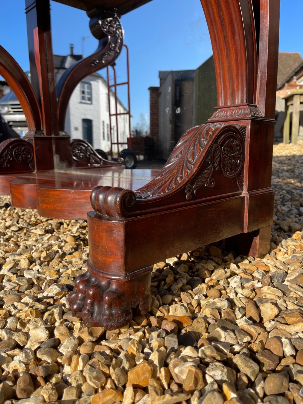 A nineteenth-century French mahogany console table featuring a dark marble top, carved S-scroll legs, and an undertier shelf on claw feet. View VII