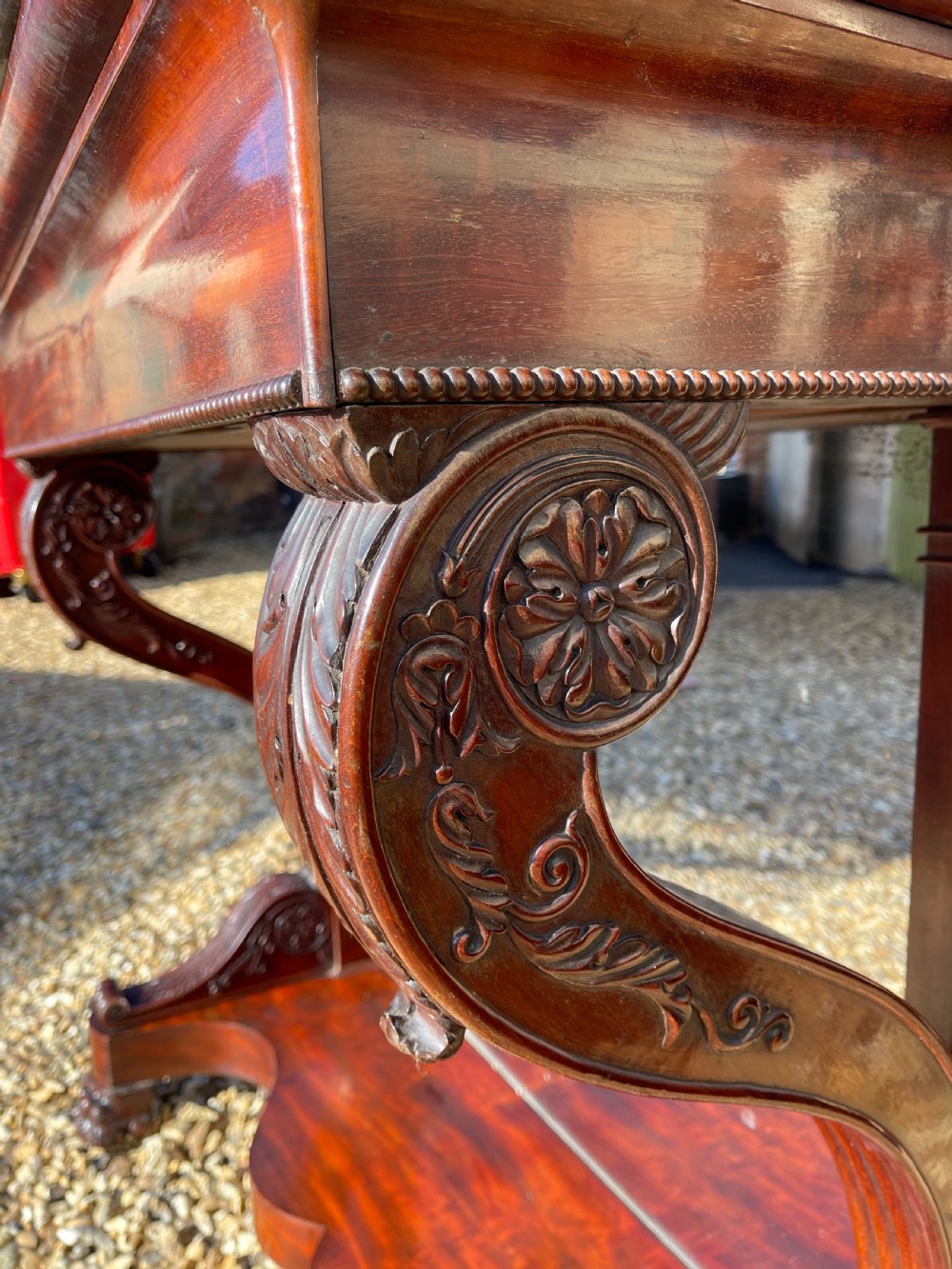 A nineteenth-century French mahogany console table featuring a dark marble top, carved S-scroll legs, and an undertier shelf on claw feet. View VIII