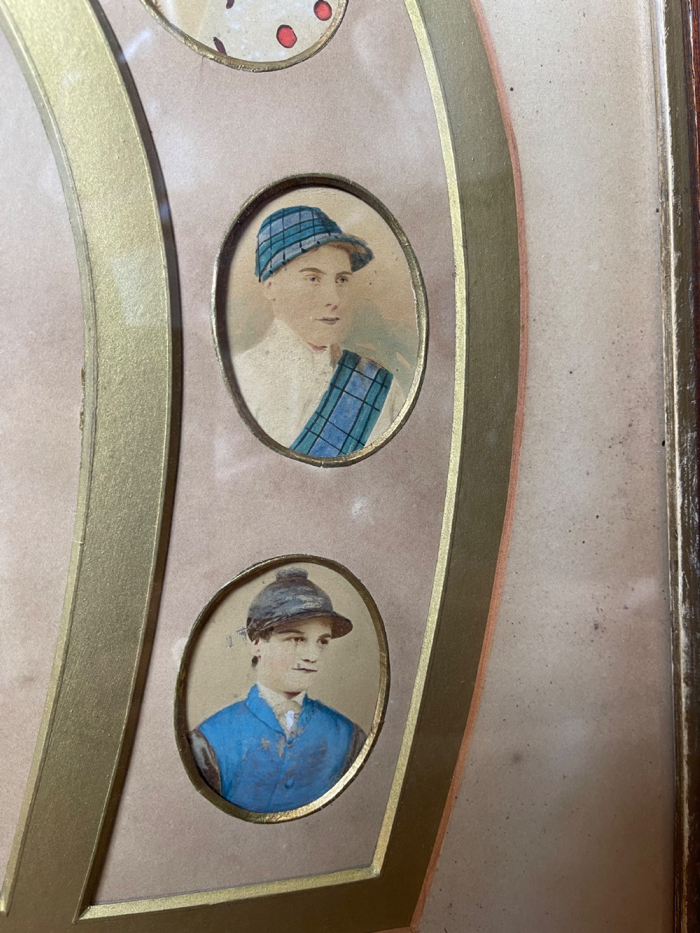 A pair of dark wood framed prints displaying miniature jockey portraits arranged inside gilded horseshoe-shaped matting. View IV