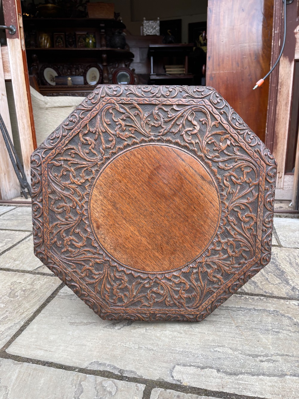 A nineteenth-century octagonal Burmese teak side table featuring intricately carved floral borders and openwork carved legs with mythical animal motifs. View II