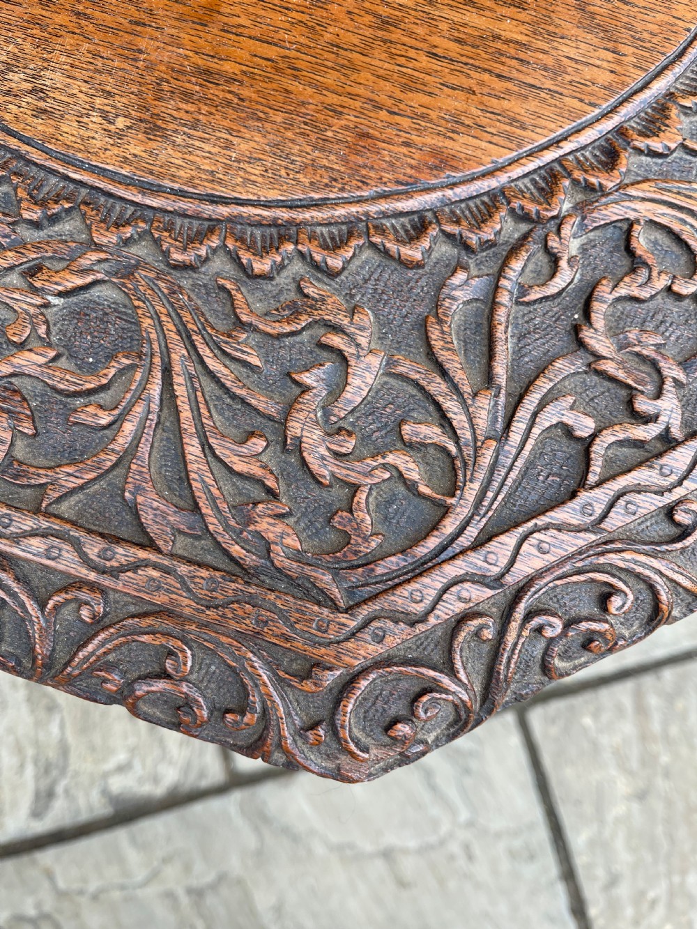 A nineteenth-century octagonal Burmese teak side table featuring intricately carved floral borders and openwork carved legs with mythical animal motifs. View IV