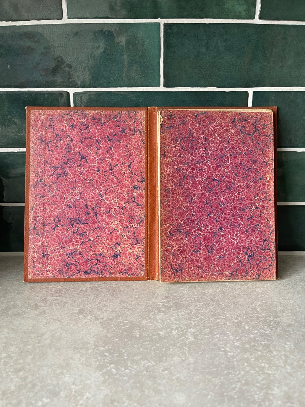 An antique terracotta cloth-bound cover for Thackers Map of Jummoo and Kashmir featuring gilt-embossed lettering and a debossed border. View IX