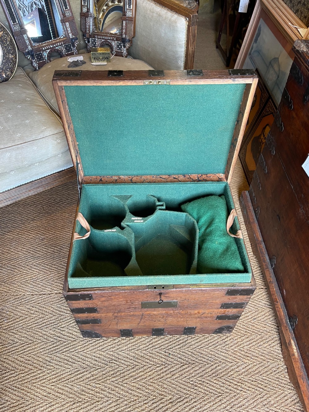 A nineteenth-century oak silver chest featuring metal corner brackets, iron strap bindings, and a central brass plate. View V