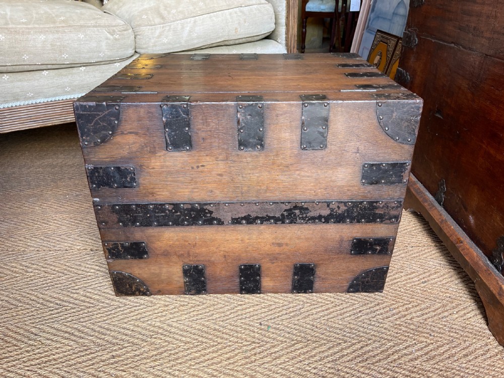 A nineteenth-century oak silver chest featuring metal corner brackets, iron strap bindings, and a central brass plate. View VII