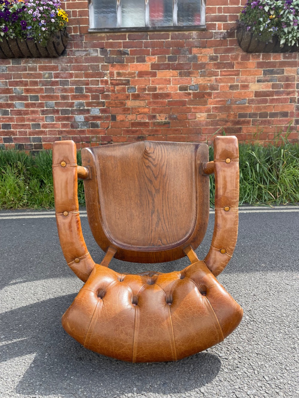 A Victorian oak desk chair featuring a deep-buttoned brown leather horseshoe backrest, turned arm supports, a shaped oak seat, and front cabriole legs on brass castors. View IV