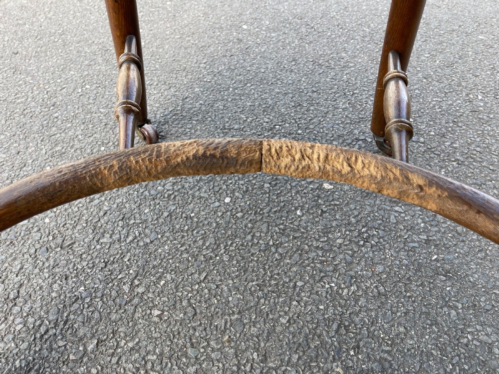 A Victorian oak desk chair featuring a deep-buttoned brown leather horseshoe backrest, turned arm supports, a shaped oak seat, and front cabriole legs on brass castors. View V