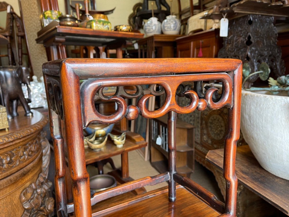 A set of four graduated dark hardwood nesting tables featuring pierced openwork aprons and bamboo-form carved legs. View III