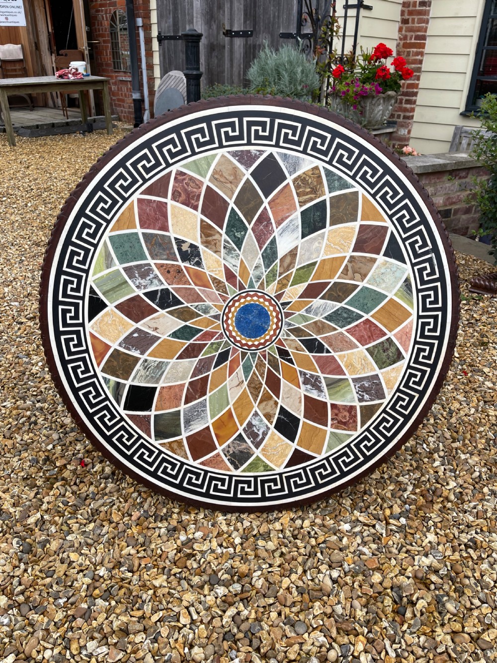 A circular nineteenth-century mahogany centre table featuring a geometric specimen marble mosaic top bordered by a Greek key pattern, supported by a carved pedestal base. View III