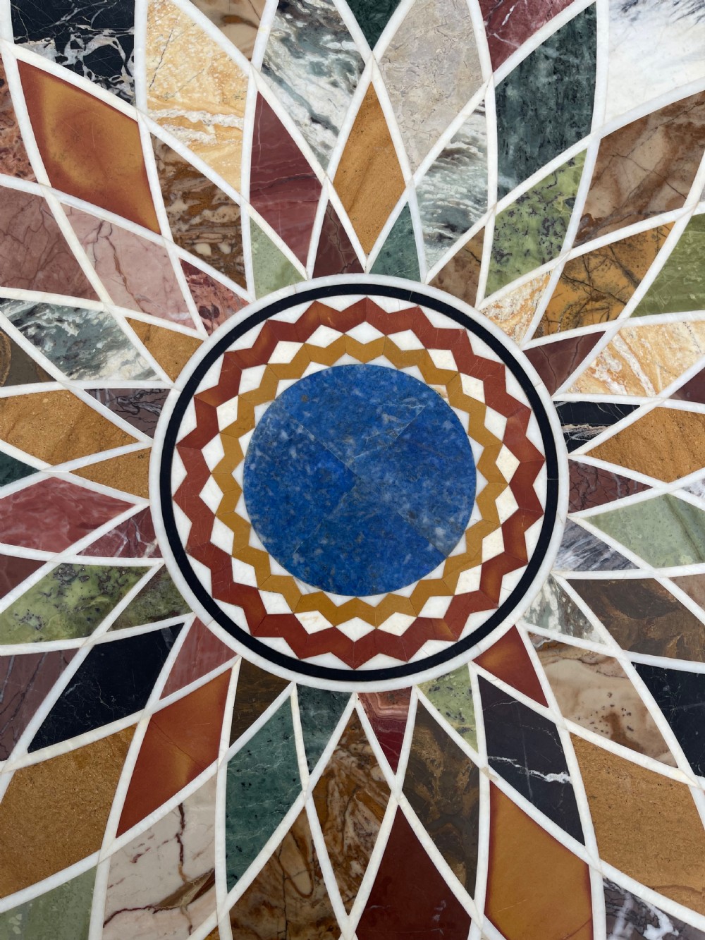 A circular nineteenth-century mahogany centre table featuring a geometric specimen marble mosaic top bordered by a Greek key pattern, supported by a carved pedestal base. View VII