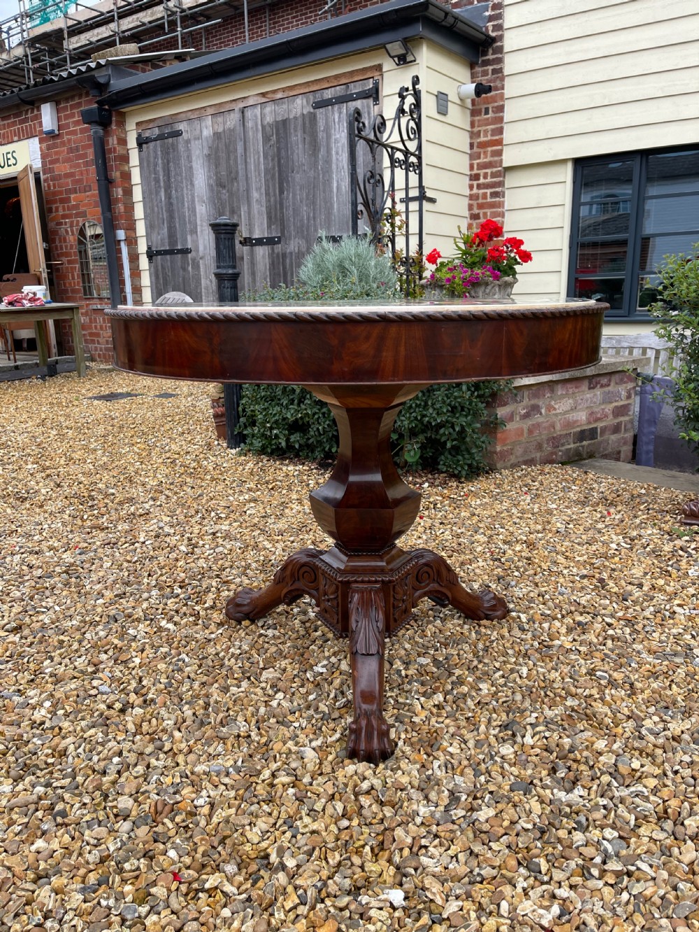 A circular nineteenth-century mahogany centre table featuring a geometric specimen marble mosaic top bordered by a Greek key pattern, supported by a carved pedestal base. View XI