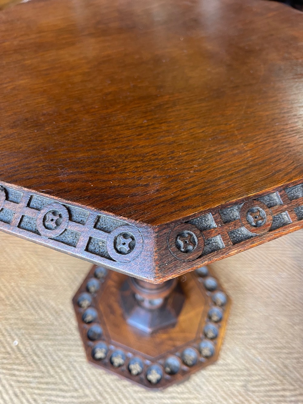 A nineteenth-century dark oak octagonal occasional table featuring a central turned column with carved quatrefoil piercings and a geometric carved base. View II
